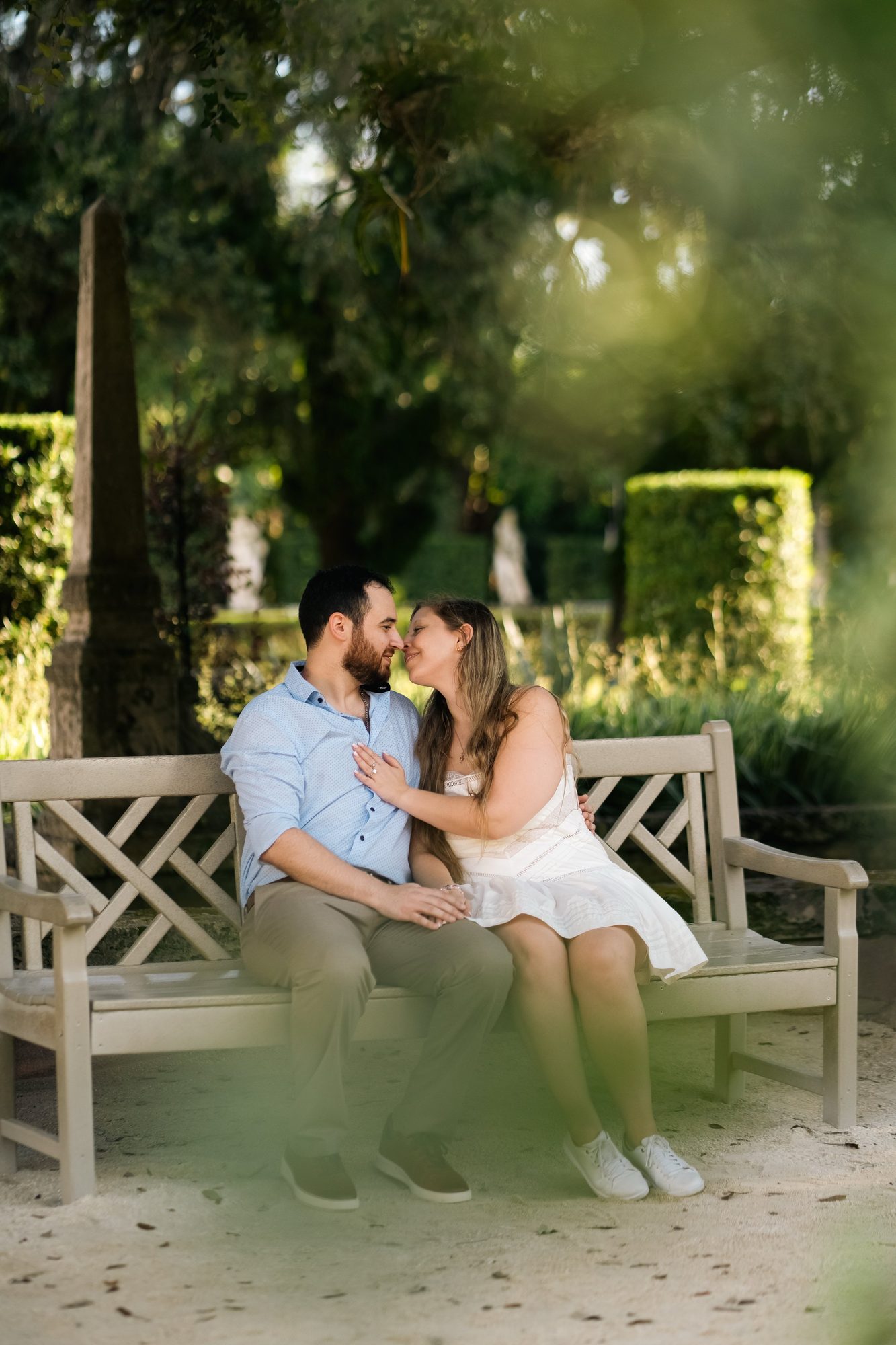 Couple embracing on a garden bench under tropical greenery