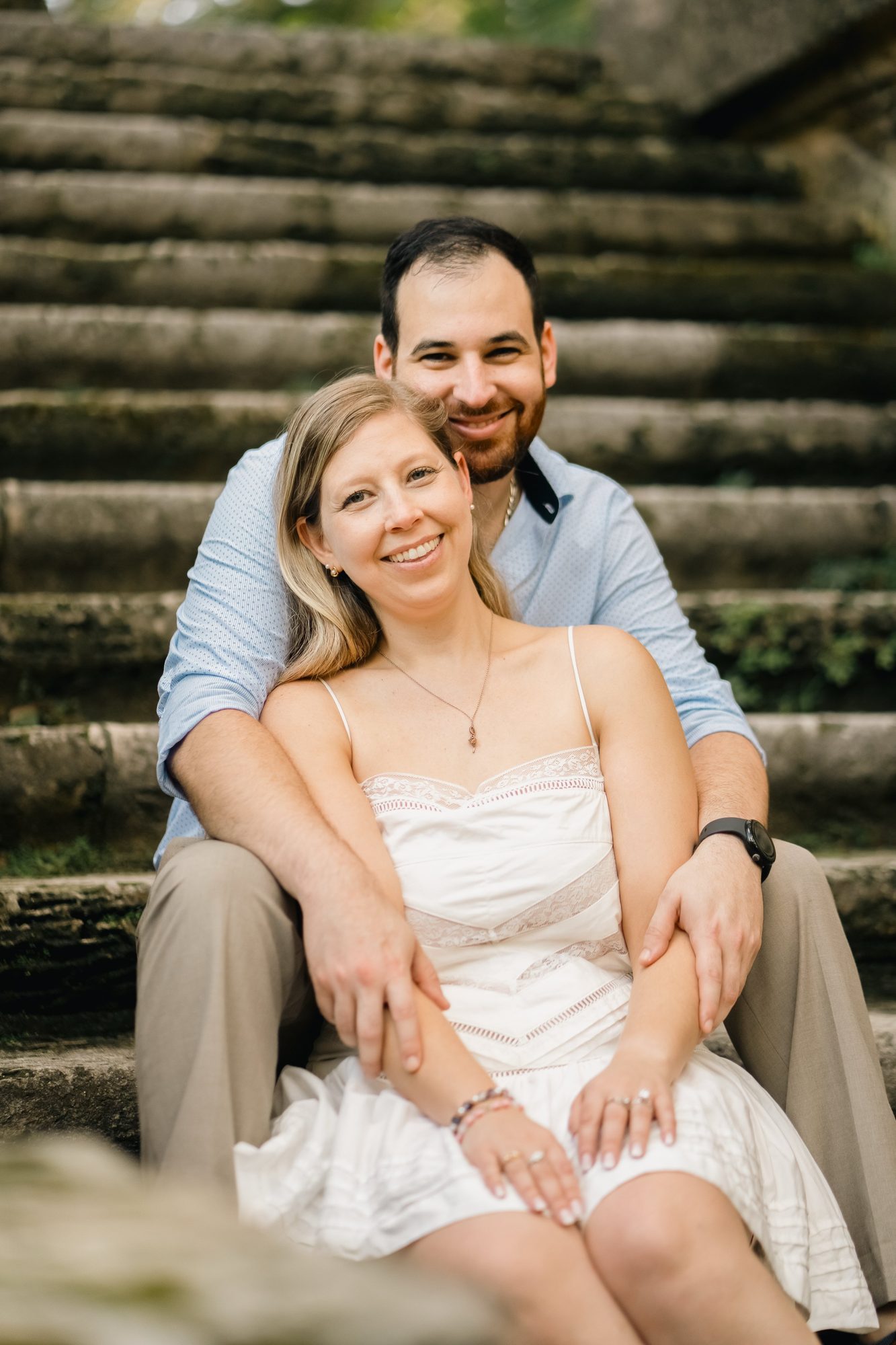 Couple sitting together on stone garden steps during portrait time