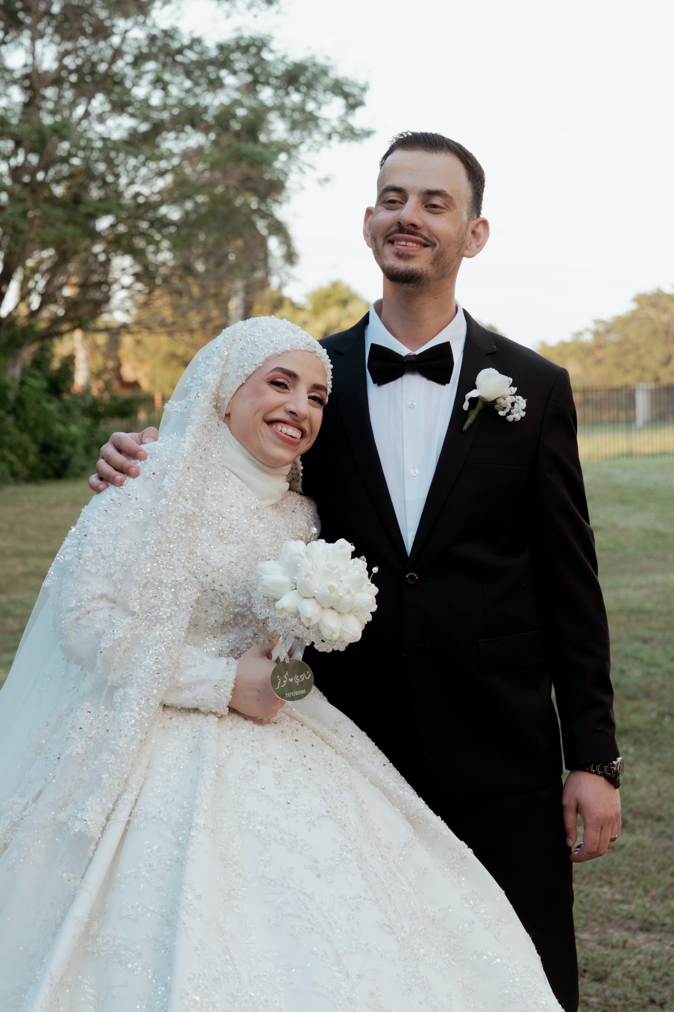 Bride laughing in the groom's embrace in a garden setting