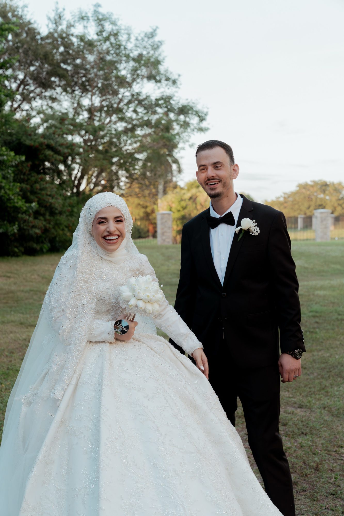 Bride laughing at the camera in a tropical garden