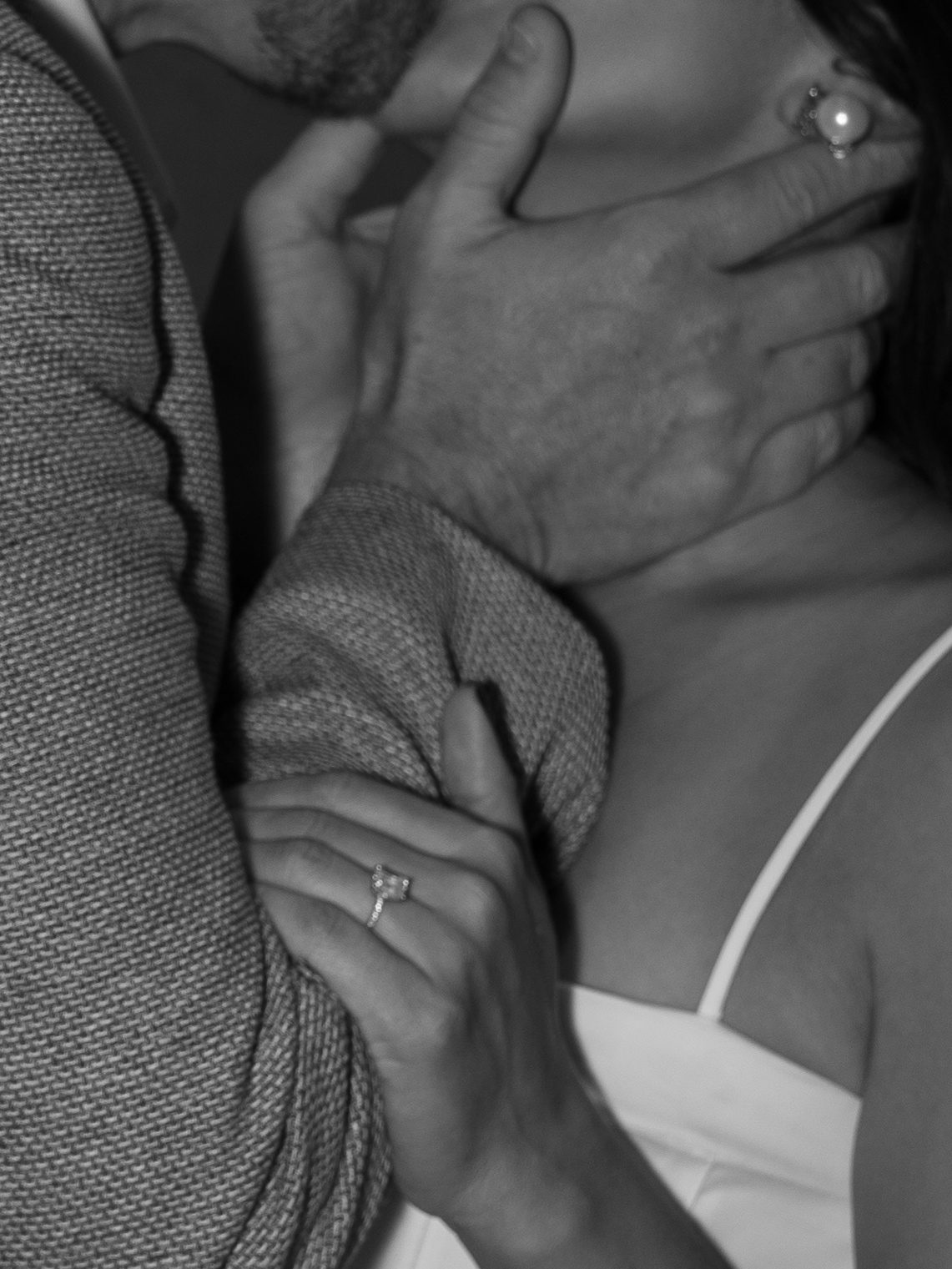 Black and white portrait of clasped hands with wedding rings