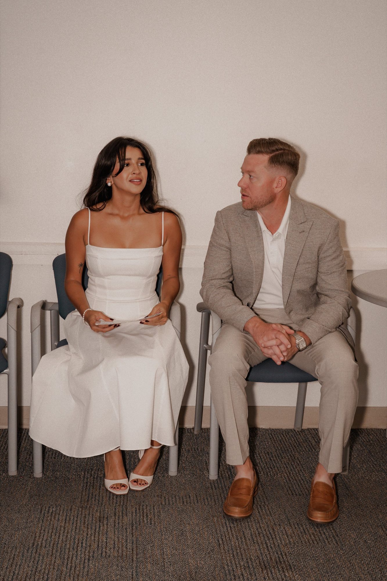 Bride and groom seated together during a quiet reception conversation