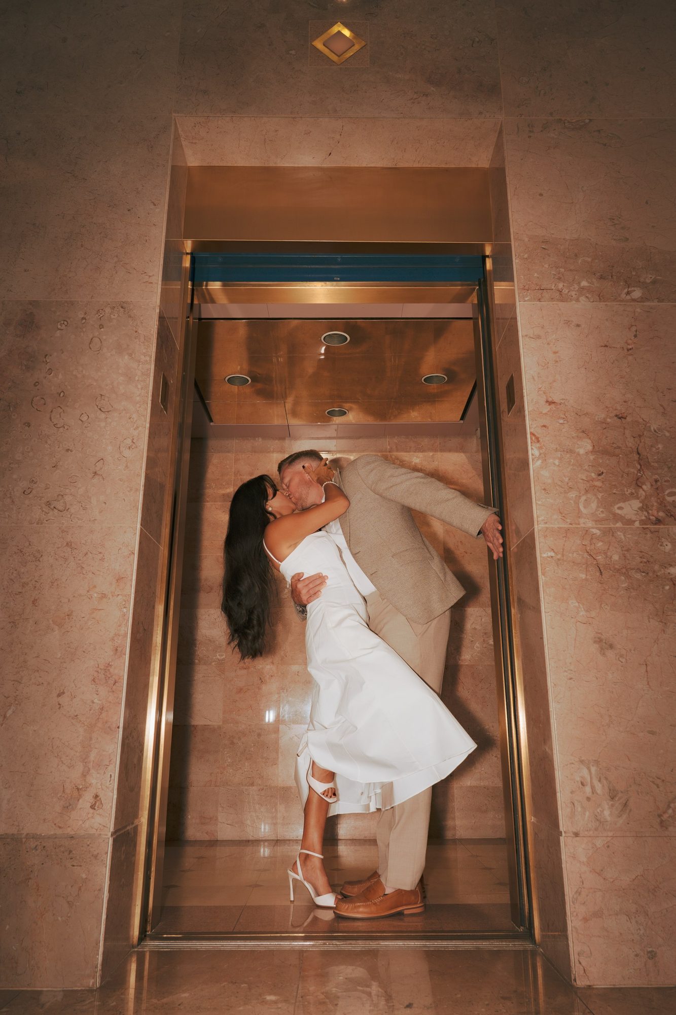 Couple kissing inside an elevator during a private wedding moment