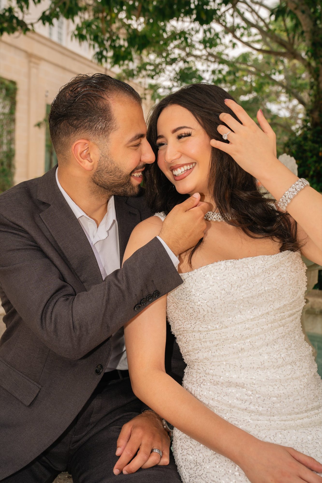 Couple laughing together under a tree canopy after their ceremony
