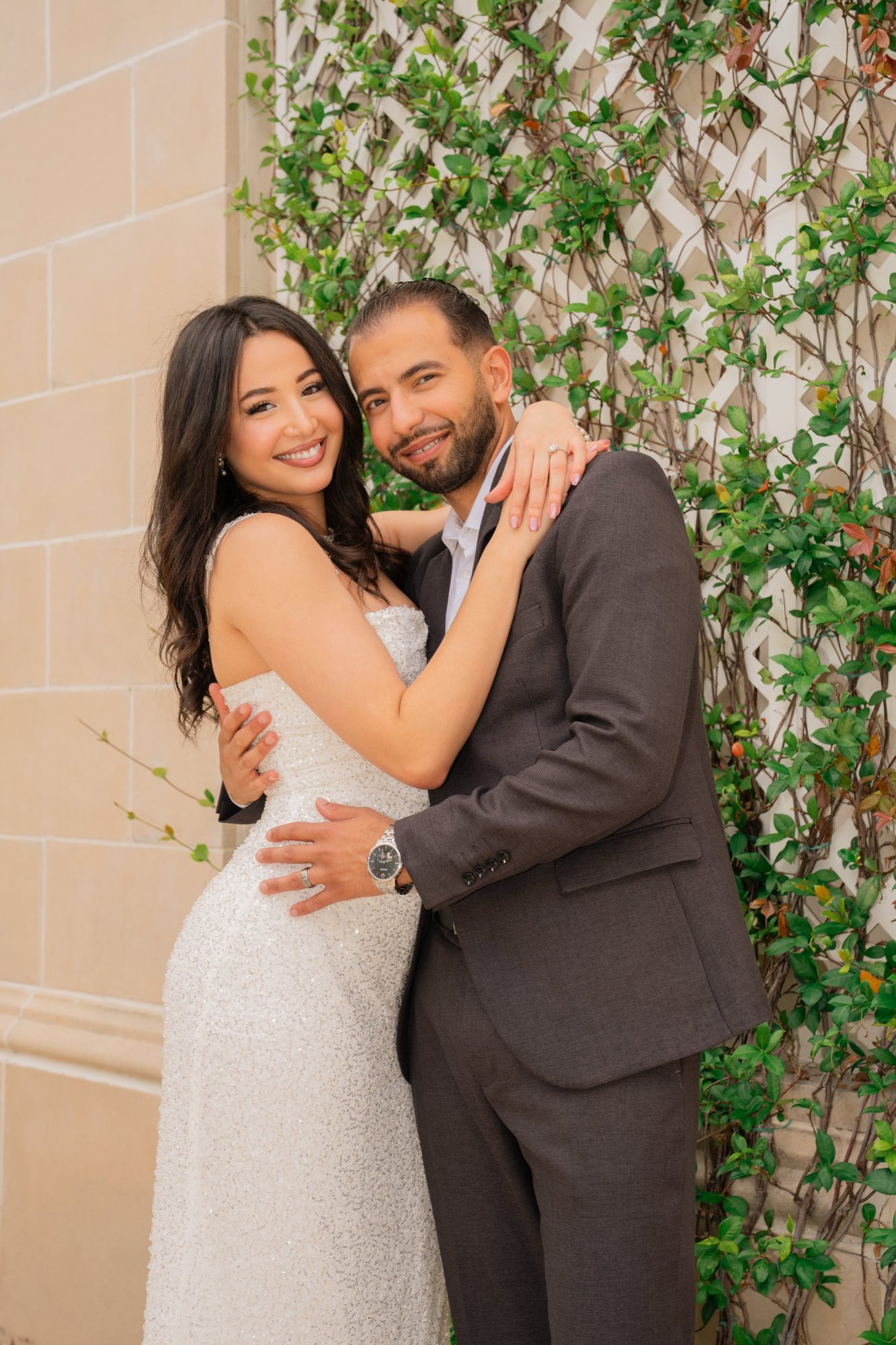 Couple embracing against an ivy covered wall after the ceremony