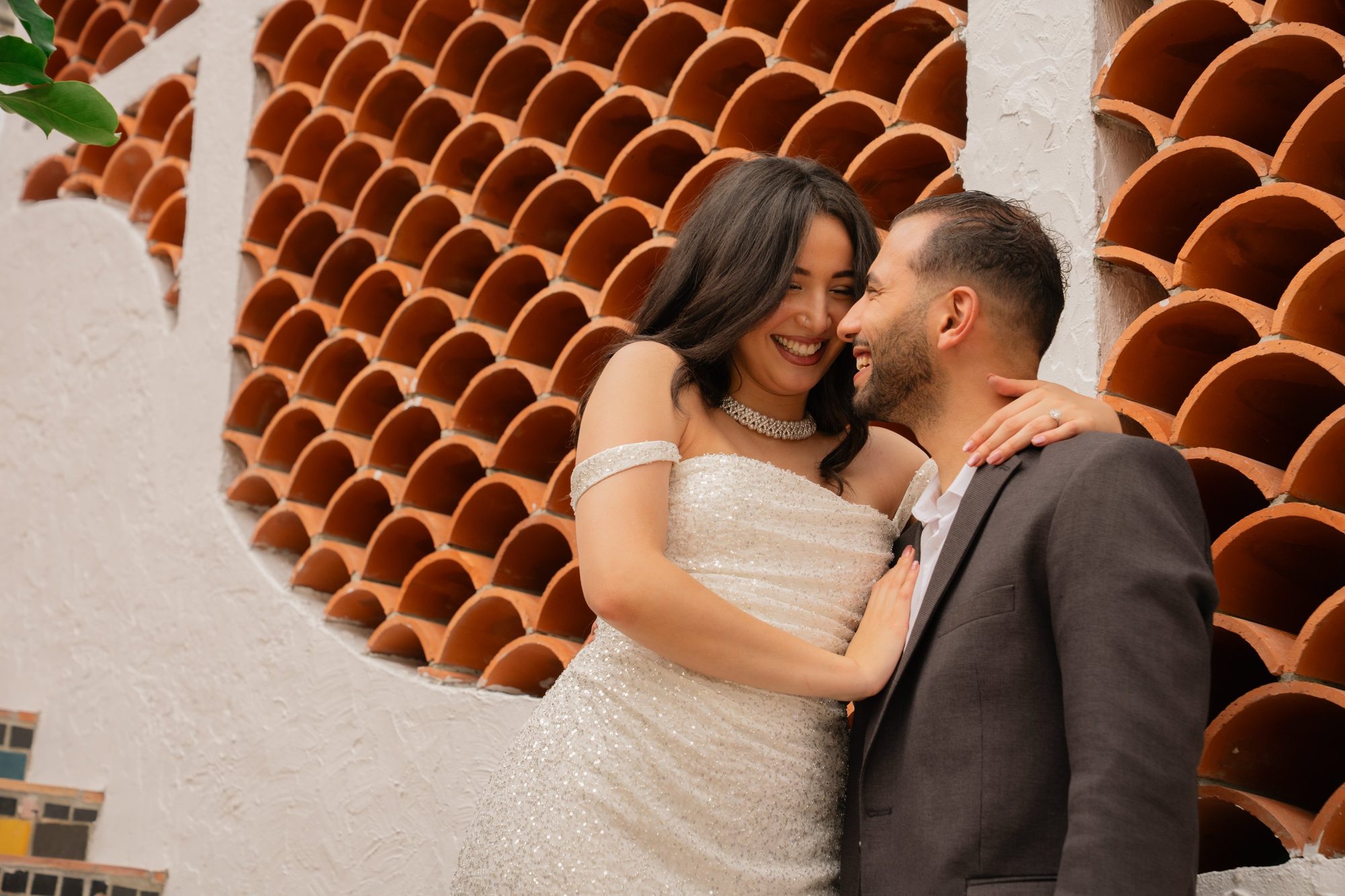 Couple laughing together against a decorative tiled wall