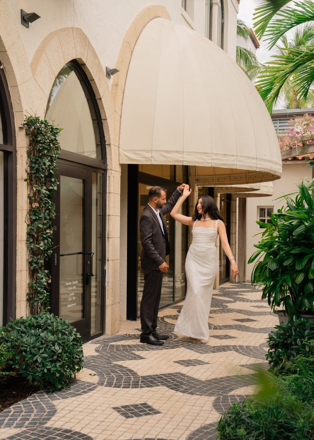 Couple dancing together outside a boutique during their wedding weekend