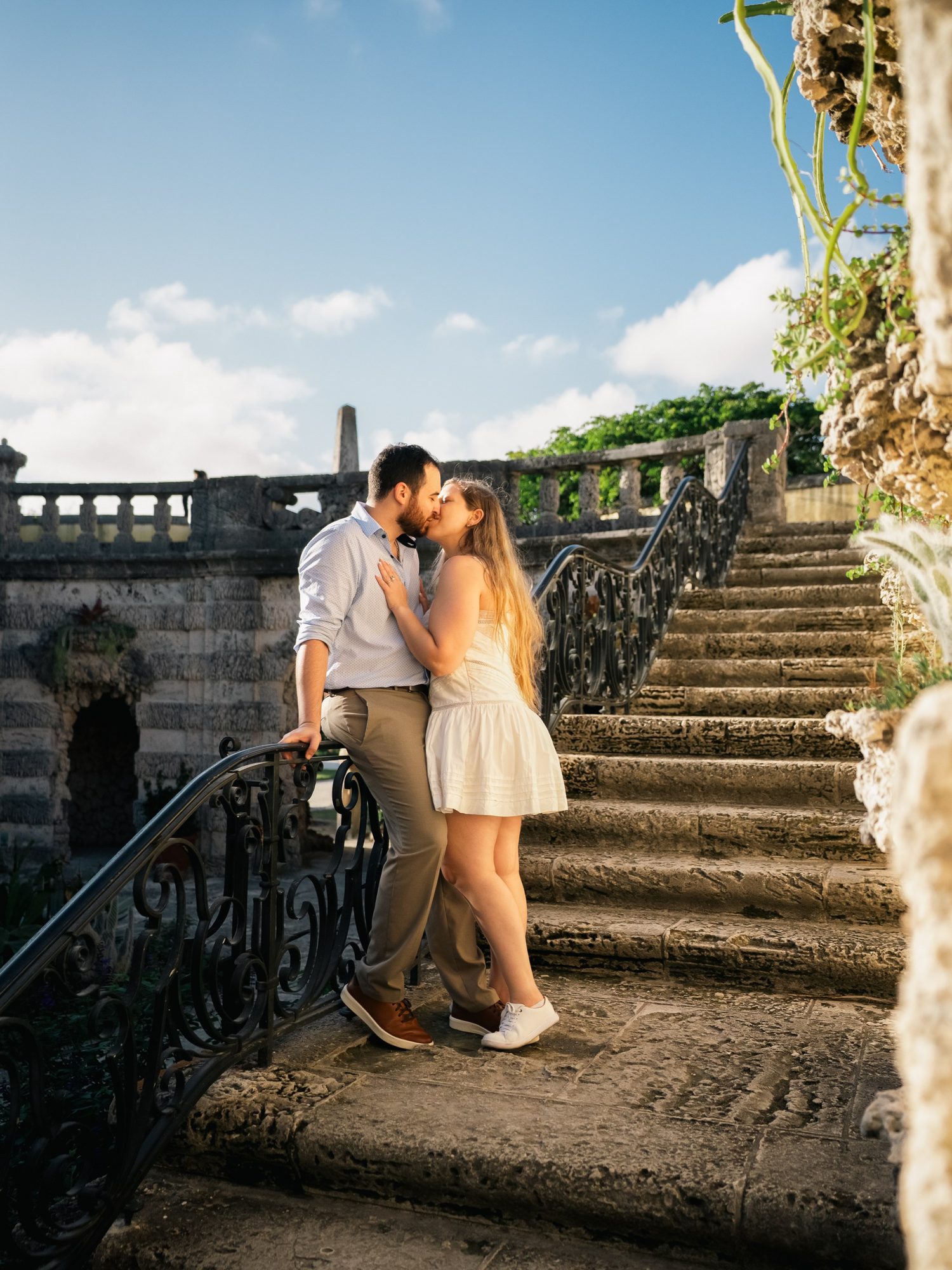 Couple kissing on a coral stone estate staircase