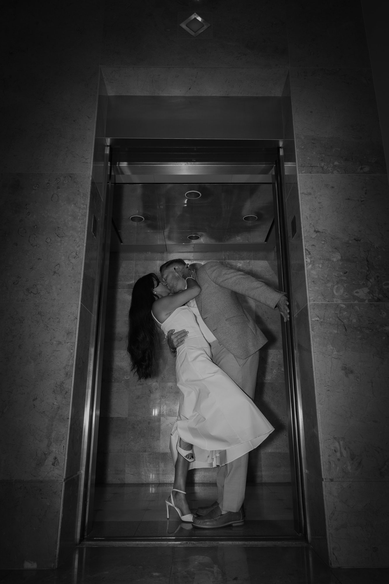 Couple kissing inside an elevator, black and white