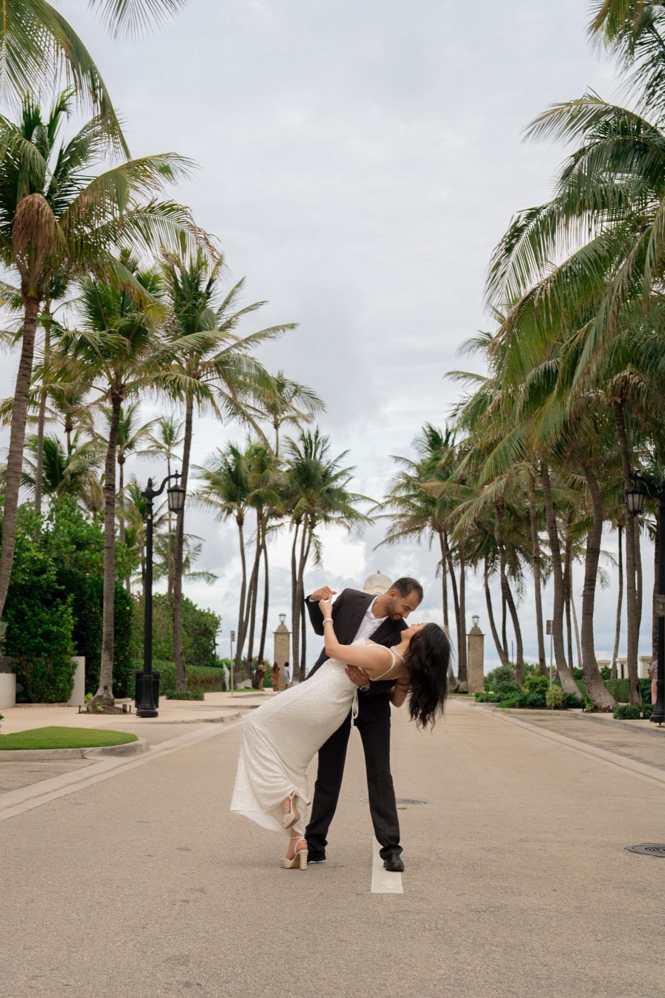 Couple dancing together on a palm lined street