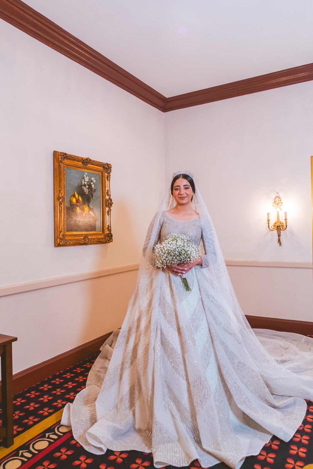 Bride in a voluminous ballgown standing in an ornate room