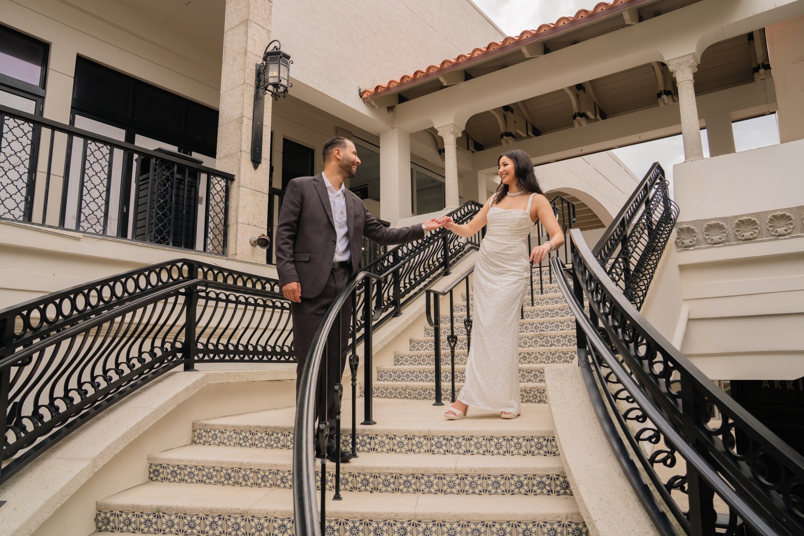 Bride and groom on the grand staircase of a Mediterranean style estate in Palm Beach